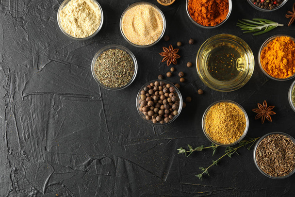 Bowls with different spices and ingredients on black background, - Photo, Image