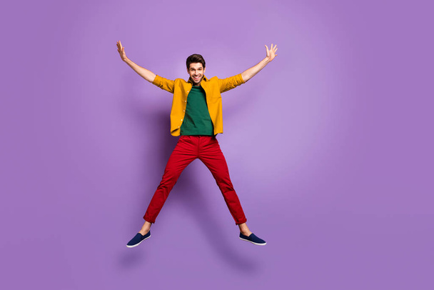 Täyspitkä kuva positiivinen iloinen kaveri hypätä nostaa kädet kuin alku nauttia kevätloma kulumista kausaalinen tyyli vaatteita eristetty yli elävä väri tausta
 - Valokuva, kuva