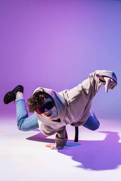 Breakdancing young man in hoodie with hair styling. Dance school poster. Copy space. Battle competition announcement. - Fotoğraf, Görsel