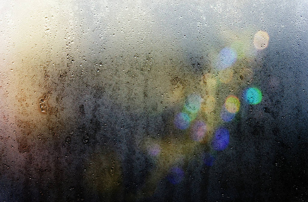 暗い夜に濡れたガラスを通して光のビーム,背景  - 写真・画像
