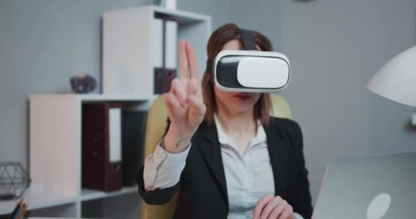 Modern business woman wearing virtual reality glasses in office. Young girl using VR goggles in office. Pretty woman working in augmented reality at workplace. - Πλάνα, βίντεο
