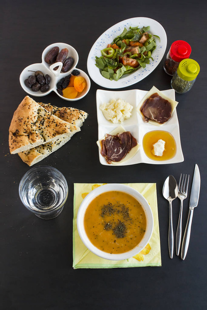 Traditional Ramadan Dinner "iftar" Table  with symbolic foods on the black surface.Muslim worship of Ramadan. - Photo, Image