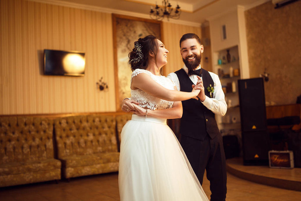 First wedding dance of newlywed. Happy bride and groom and their first dance in the elegant restaurant. Married couple having fun. Wedding day. Together.  - Photo, Image