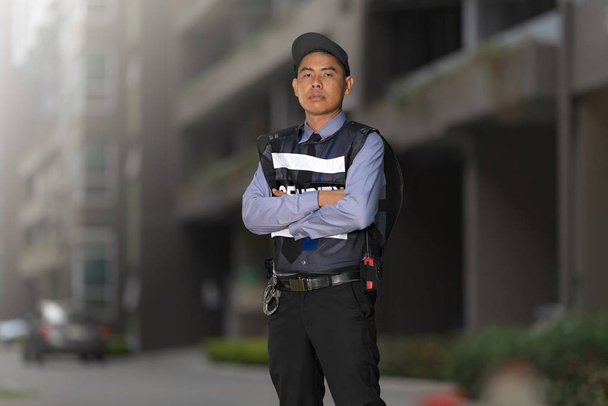 Охранник, стоящий снаружи возле большого здания
  - Фото, изображение