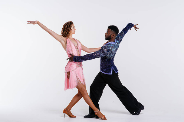 Czarny mężczyzna i biała kobieta tańczą razem, koncepcja fitness. Tancerze na białym tle - Zdjęcie, obraz
