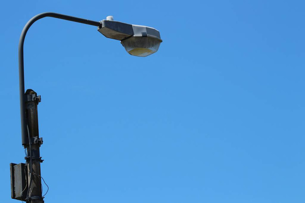 A street lamp with a clear blue sky in the background at daytime - Фото, изображение