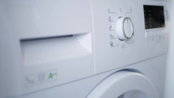 Man Put Dirty Clothes in Laundry Machine Set the Program and Push Power On - Felvétel, videó