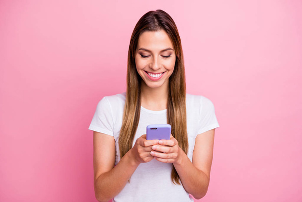 Which picture is best. Photo of pretty lady holding telephone hands texting friends sending new just made selfies wear casual white t-shirt isolated pink color background - Фото, зображення