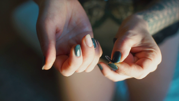 Μια γυναίκα σκίζει ένα ψεύτικο νύχι από το δάχτυλό της.. - Πλάνα, βίντεο