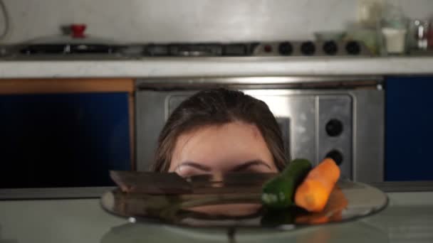 Mädchen guckt vom Tisch und nimmt Schokoriegel vom Teller - Filmmaterial, Video