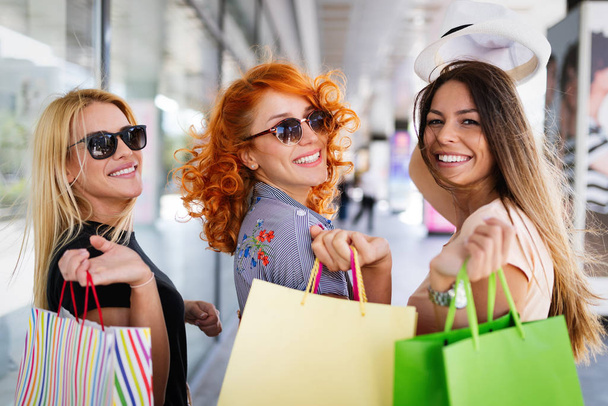 Freundinnen mit Einkaufstüten haben Spaß beim Einkaufen in einem Einkaufszentrum, Geschäften - Foto, Bild