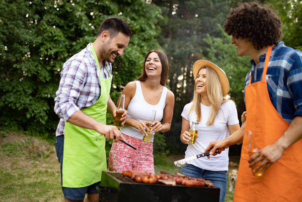 Friends having fun in nature doing barbecue - 写真・画像