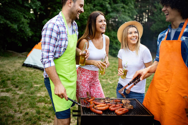 Friends having fun in nature doing barbecue - Фото, изображение