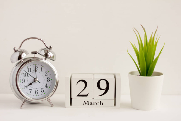 March 29 on a wooden calendar next to the alarm clock.Calendar date, holiday event, or birthday - Foto, Imagem