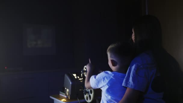 A gyerekek rajzfilmet néznek egy régi filmvetítőn. - Felvétel, videó