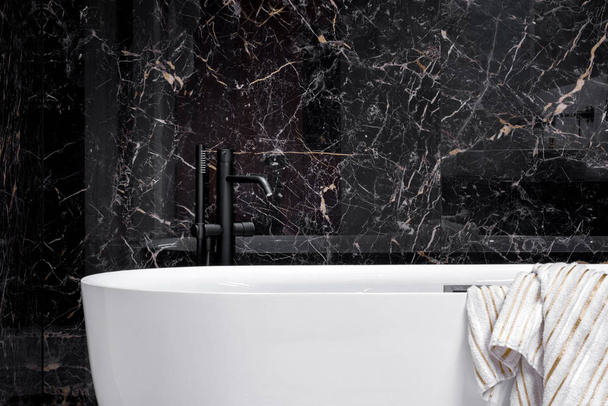 Black faucet in elegant white bathtub - Фото, зображення