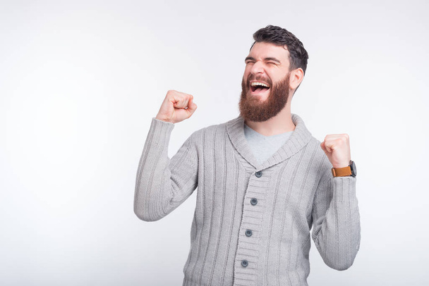 Photo of happy man celebrating success while standing over white - Фото, изображение