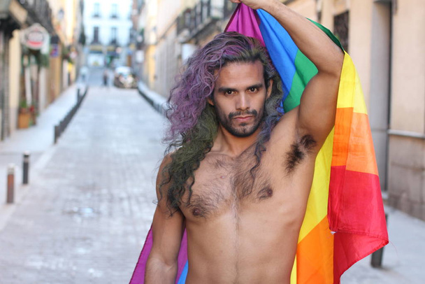 Nahaufnahme Porträt eines hübschen jungen, hemdlosen schwulen Mannes mit lgbt-Fahne auf der Straße - Foto, Bild