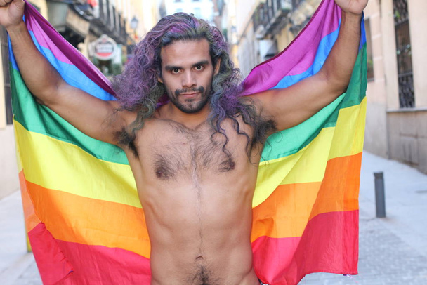 κοντινό πορτραίτο ενός όμορφου νεαρού γκέι άντρα χωρίς μπλούζα με σημαία lgbt στο δρόμο - Φωτογραφία, εικόνα