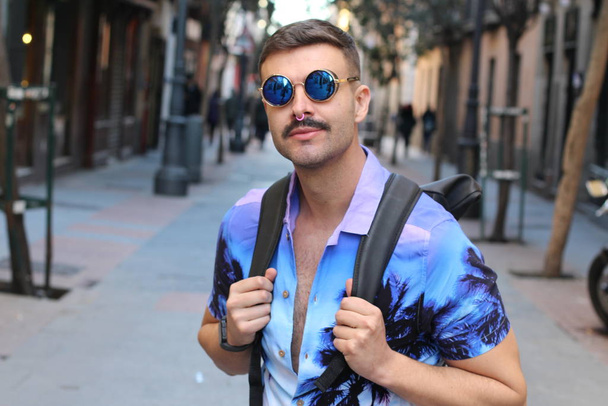 Nahaufnahme Porträt eines hübschen jungen Mannes in stylischem lila Hemd und Sonnenbrille auf der Straße - Foto, Bild