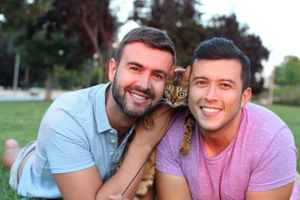 Gay couple in the park with their pet - Foto, afbeelding