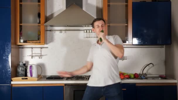 man sings using cucumber as microphone and grimaces jumping - Footage, Video