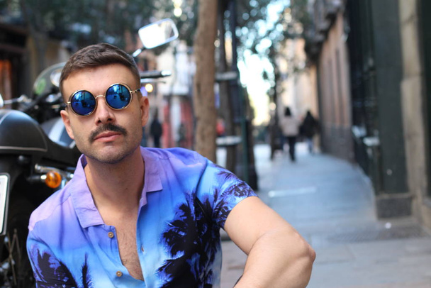 ストリートでスタイリッシュな紫のシャツとサングラスでハンサムな若い男のクローズアップ肖像画 - 写真・画像