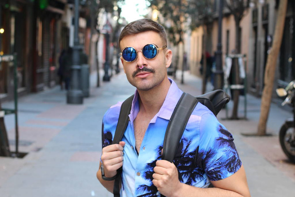 közeli kép jóképű fiatalember elegáns lila ing és napszemüveg az utcán - Fotó, kép