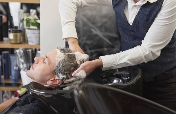 Κοντινό πλάνο του κουρέα πλύσιμο των μαλλιών άνθρωπος  - Φωτογραφία, εικόνα