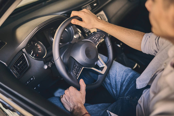 Male hand holding a steering wheel before purchasing a new autom - Fotó, kép