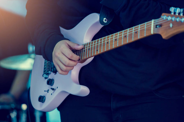 Ręce muzyka grającego na gitarze elektrycznej na koncercie na scenie - Zdjęcie, obraz