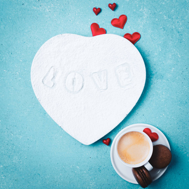 Beyaz tabakta aşk harfleri, bir fincan kahve ve kurabiyelerle yaratılmış yaratıcı bir düzen. Tebrik kartı. Renkli turkuaz arkaplan. - Fotoğraf, Görsel