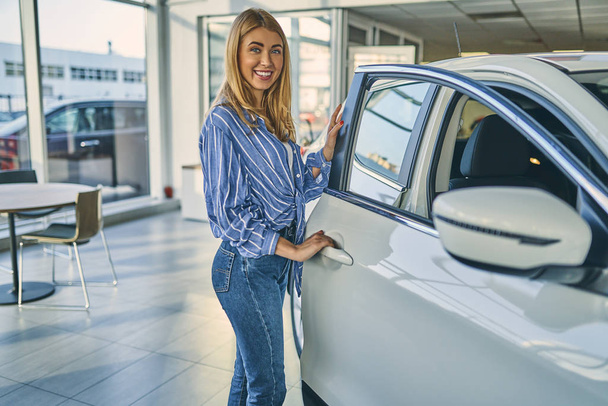Cheerful girl choosing a new car. - Фото, изображение