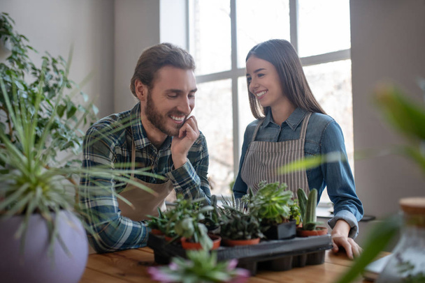 Smiling couple taking care of plants together - Photo, Image