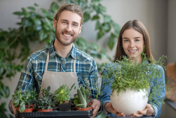 Man and woman holding various plants in hands - Photo, Image