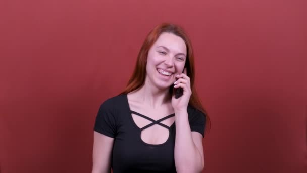 A young woman with red hair is talking on the phone. People sincere emotions, lifestyle concept. - Filmagem, Vídeo