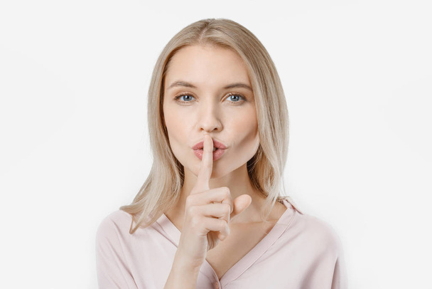 Portrait of attractive girl with finger on lips isolated over white background - Photo, Image