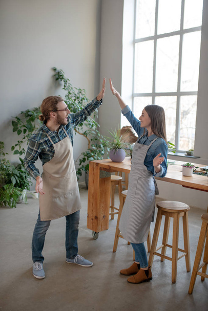 Joyful man and woman divving high five to each other - Photo, image