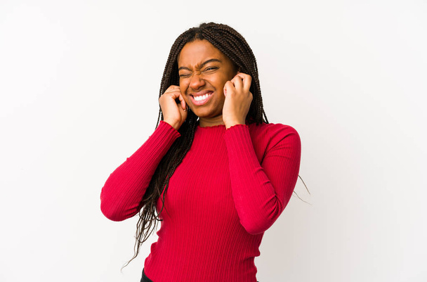 若いアフリカ系アメリカ人女性は耳を手で覆う. - 写真・画像