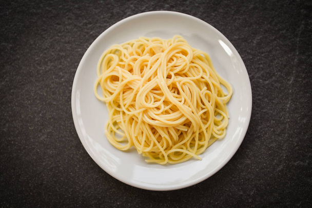 Makaron włoski spaghetti podawany na białym talerzu z jedzeniem spaghetti i - Zdjęcie, obraz