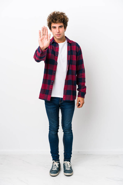 Koko kehon nuori valkoihoinen mies eristetty seisoo ojennetulla kädellä osoittaa stop-merkki, estää sinua
. - Valokuva, kuva
