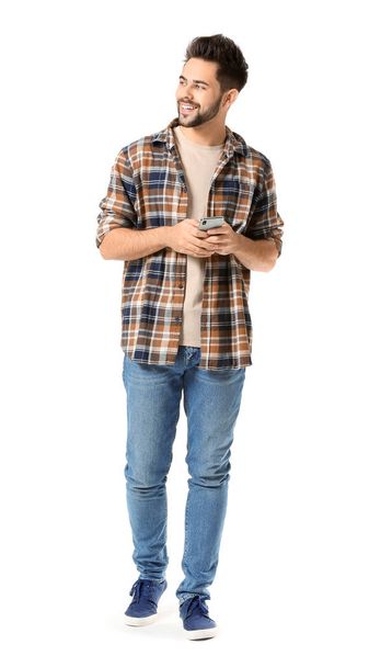 Happy young man with mobile phone on white background - Photo, image