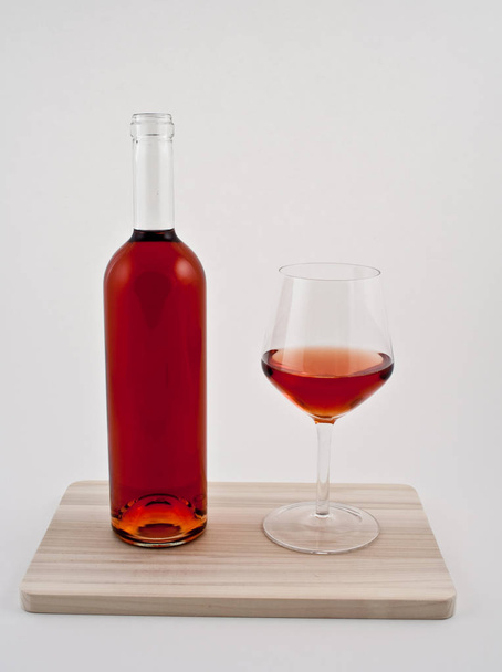 glass of red wine and a bottle of brandy on a white background - Φωτογραφία, εικόνα