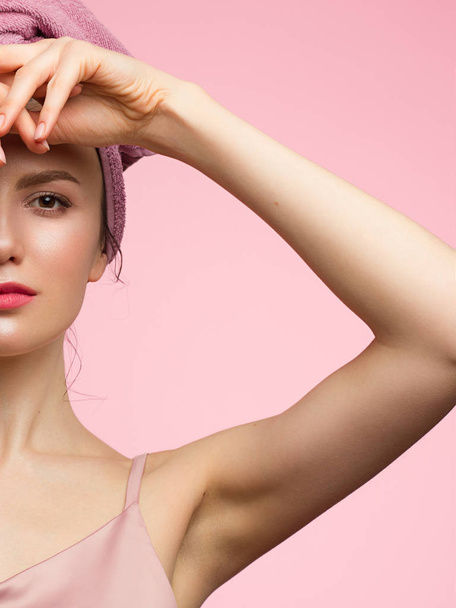 Beautiful young woman with clean perfect skin. Portrait of beauty model with natural nude make up and touching her face. Spa, skincare and wellness. Close up, pink background, copyspace. - 写真・画像