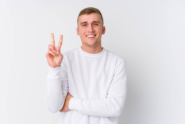 Fiatal fehér férfi fehér háttér mutatja a második számú ujjak. - Fotó, kép