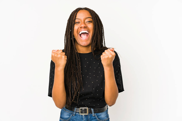 Young african american woman isolated on white background cheering carefree and excited. Victory concept. - Fotó, kép