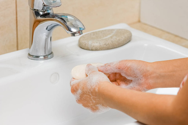 conceito de higiene. lavar as mãos com sabão sob a torneira com w
 - Foto, Imagem