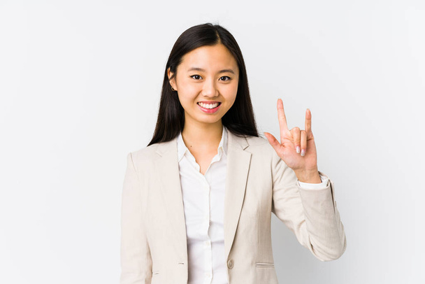 Νεαρή Κινέζα επιχειρηματίας απομονωμένη δείχνοντας μια χειρονομία κέρατο ως επαναστατική έννοια. - Φωτογραφία, εικόνα