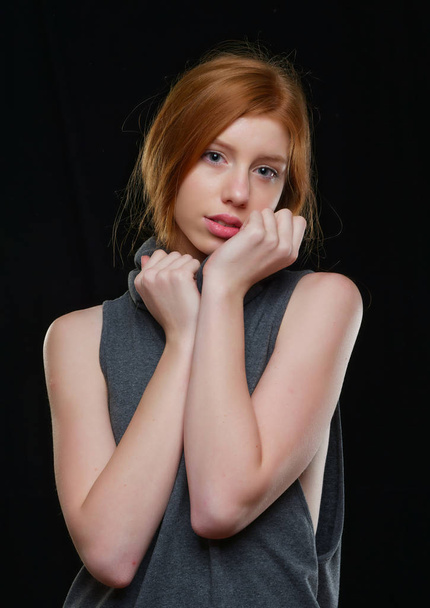young girl with long red hair on a black background - Foto, afbeelding