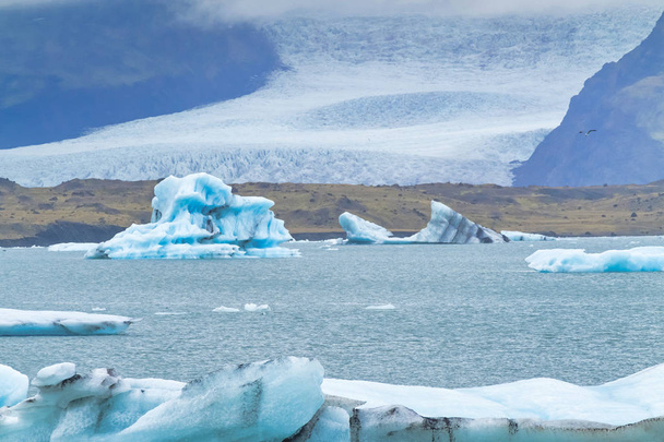 Icebergs flotando en el agua fría de la laguna glacial de Jokulsarlon. Parque Nacional Vatnajokull, en el sureste de Islandia durante un viaje por carretera
 - Foto, Imagen